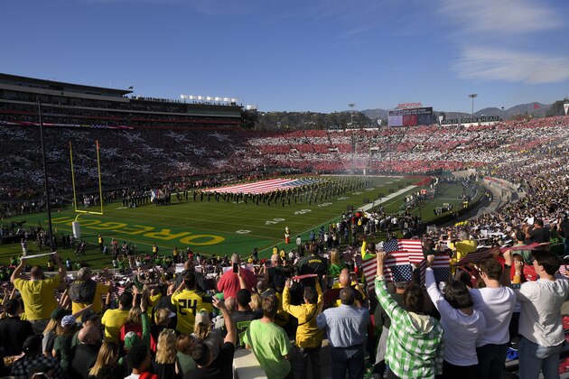 FILE - In this Jan. 1, 2020, file photo, fans stand for the national anthem before the Rose Bowl NCAA college football game between Oregon and Wisconsin in Pasadena, Calif. No spectators will be allowed at the Rose Bowl for the College Football Playoff semifinal on Jan. 1 because of COVID-19 restrictions imposed by the state, county and city of Pasadena, The Tournament of Roses said Thursday, Dec. 3, 2020. (AP Photo/Mark J. Terrill, File)