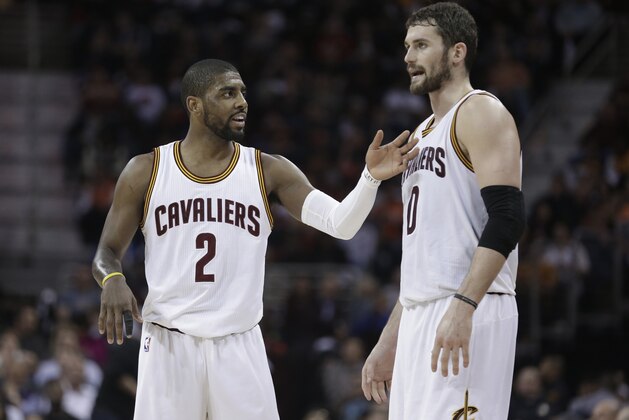 Cleveland Cavaliers' Kyrie Irving, left, talks with Kevin Love during an NBA basketball game against the Miami Heat Wednesday, Feb. 11, 2015, in Cleveland. (AP Photo/Tony Dejak)