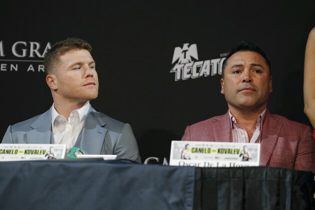 Canelo Alvarez, left, looks at promoter and former boxer Oscar de la Hoya during a news conference Wednesday, Oct. 30, 2019, in Las Vegas. Alvarez is scheduled to fight Sergey Kovalev in a WBO light heavyweight title bout Saturday in Las Vegas. (AP Photo/John Locher)