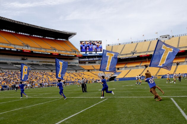 Cheerleaders carry flags spelling out Pitt after a score at Heinz Field during their annual intrasquad Blue-Gold spring NCAA football game, Saturday, April 13, 2019, in Pittsburgh. The Blue team won 14-7. (AP Photo/Keith Srakocic)