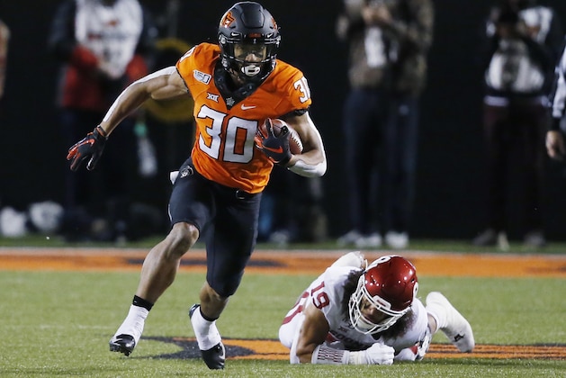 FILE - In this Nov. 30, 2019, file photo, Oklahoma State running back Chuba Hubbard (30) carries past Oklahoma linebacker Caleb Kelly during an NCAA college football game in Stillwater, Okla. Hubbard was selected to The Associated Press preseason All-America first-team, Tuesday, Aug. 25, 2020. (AP Photo/Sue Ogrocki, File)