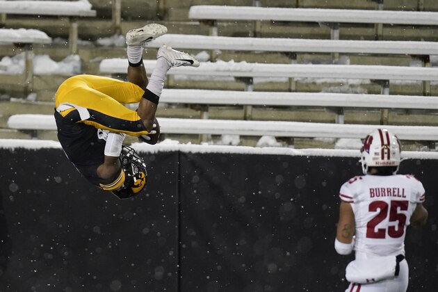 Iowa wide receiver Ihmir Smith-Marsette, left, flips in the end zone in front of Wisconsin safety Eric Burrell, right, after catching a 53-yard touchdown pass during the second half of an NCAA college football game, Saturday, Dec. 12, 2020, in Iowa City, Iowa. Iowa won 28-7. (AP Photo/Charlie Neibergall)