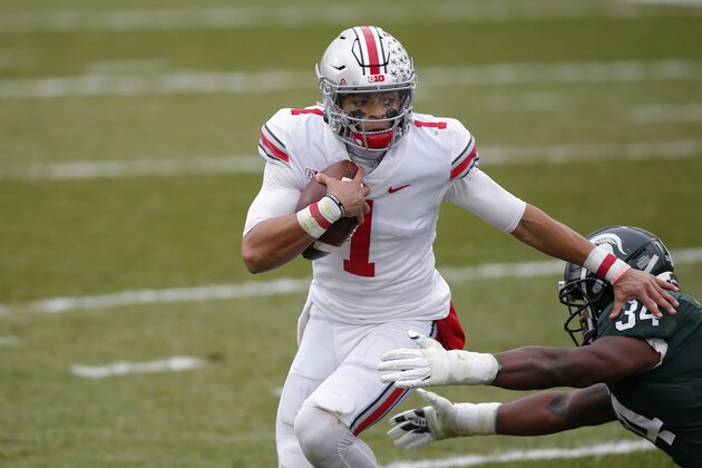Ohio State quarterback Justin Fields, left, scrambles against Michigan State's Antjuan Simmons during an NCAA college football game, Saturday, Dec. 5, 2020, in East Lansing, Mich. Ohio State won 52-12. (AP Photo/Al Goldis)