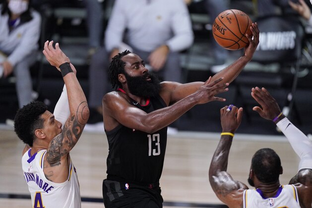 Houston Rockets' James Harden (13) drives to the basket between Los Angeles Lakers' Danny Green, left, and LeBron James, right, during the second half of an NBA conference semifinal playoff basketball game Tuesday, Sept. 8, 2020, in Lake Buena Vista, Fla. (AP Photo/Mark J. Terrill)