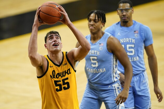 Iowa center Luka Garza (55) drives to the basket ahead of North Carolina forward Armando Bacot (5) and forward Garrison Brooks, right, during the second half of an NCAA college basketball game, Tuesday, Dec. 8, 2020, in Iowa City, Iowa. Iowa won 93-80. (AP Photo/Charlie Neibergall)