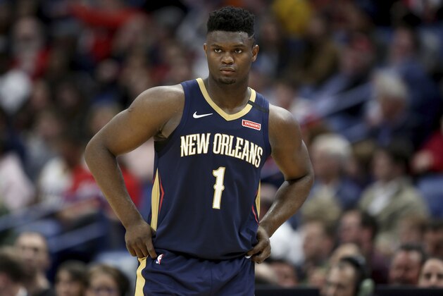 FILE - In this March 6, 2020, file photo, New Orleans Pelicans forward Zion Williamson walks onto the court during the second half of the team's NBA basketball game against the Miami Heat in New Orleans. The rookie sensation’s availability to play remained unclear as the season’s resumption in Lake Buena Vista, Florida, approached. He left the NBA’s so-called “bubble” setup on July 16 to attend to an unspecified family medical matter. A week later, the club had yet to provide an update on his possible return.  (AP Photo/Rusty Costanza, File)