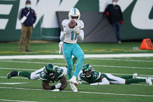 Miami Dolphins' DeVante Parker makes a catch in front of New York Jets defenders during the first half of an NFL football game, Sunday, Nov. 29, 2020, in East Rutherford, N.J. (AP Photo/Corey Sipkin)