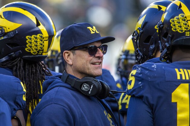 FILE  - In this Nov. 16, 2019, file photo, Michigan head coach Jim Harbaugh huddles with his players on the field during a time out in the fourth quarter of an NCAA college football game against Michigan State in Ann Arbor, Mich. Jim Harbaugh enters his sixth season as Michigan's coach with just two years left on his contract, adding another layer of interest in the 18th-ranked Wolverines as they kick off the season this week at No. 21 Minnesota.  (AP Photo/Tony Ding, File)