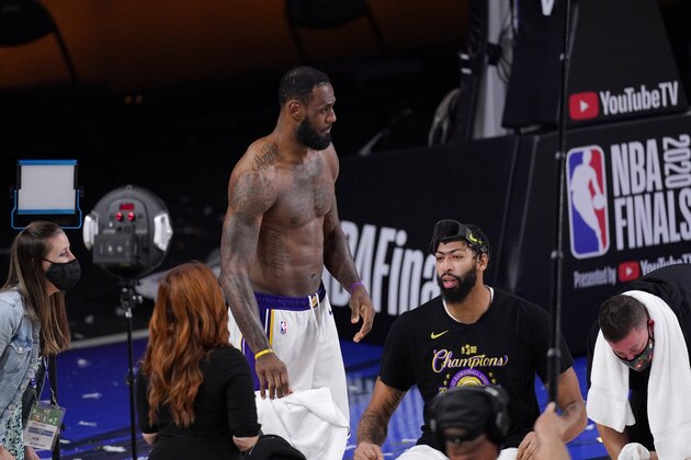 Los Angeles Lakers' LeBron James (23) and Anthony Davis (3) prepare for a TV interview after the Lakers defeated the Miami Heat 106-93 in Game 6 of basketball's NBA Finals Sunday, Oct. 11, 2020, in Lake Buena Vista, Fla. (AP Photo/Mark J. Terrill)