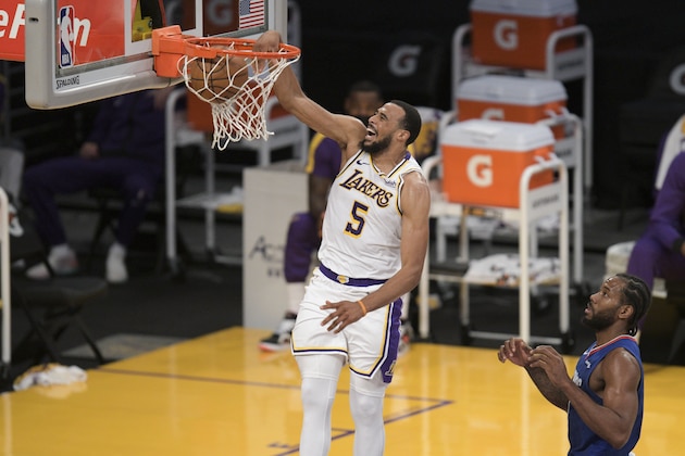 Los Angeles Lakers guard Talen Horton-Tucker, left, dunks past Los Angeles Clippers forward Kawhi Leonard during the first half of an NBA preseason basketball game in Los Angeles, Sunday, Dec. 13, 2020. (AP Photo/Kyusung Gong)