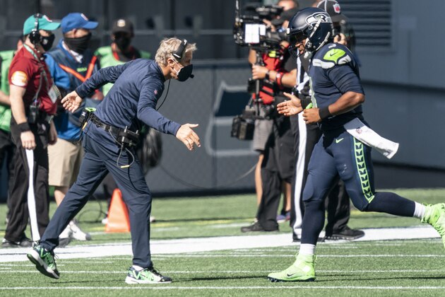 Seattle Seahawks head coach Pete Carroll, left, congratulates quarterback Russell Wilson after a score during the first half of an NFL football game against the Dallas Cowboys, Sunday, Sept. 27, 2020, in Seattle. (AP Photo/Stephen Brashear)