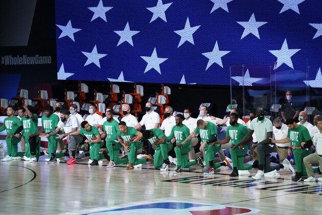 Players and staff of the Boston Celtics gather for the national anthem before Game 1 of the NBA basketball Eastern Conference final against the Miami Heat on Tuesday, Sept. 15, 2020, in Lake Buena Vista, Fla. (AP Photo/Mark J. Terrill)