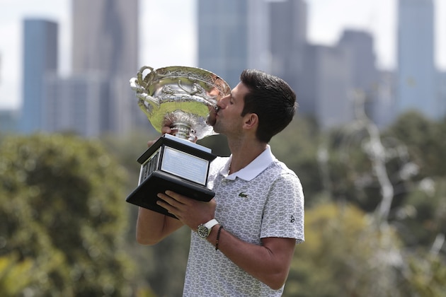 Serbia's Novak Djokovic kisses his trophy, the Norman Brookes Challenge Cup, during a photo shoot at Melbourne's Royal Botanic Gardens following his win over Austria's Dominic Thiem in the men's singles final at the Australian Open tennis championships, in Melbourne, Australia, Monday, Feb. 3, 2020. (AP Photo/Dita Alangkara)