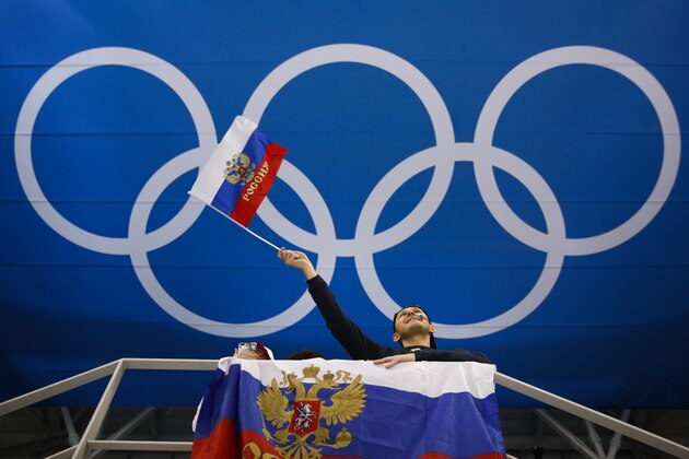 A fan waves a flag of Russia before the quarterfinal round of the men's hockey game between Norway and the team from Russia at the 2018 Winter Olympics in Gangneung, South Korea, Wednesday, Feb. 21, 2018. (AP Photo/Jae C. Hong)