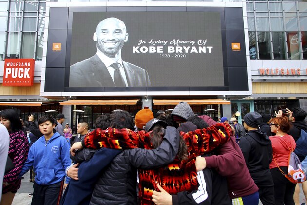 Fans of Kobe Bryant mourn in front of his image at the LALive area across from Staples Center, home of the Los Angeles Lakers, after word of the Lakers star's death in a helicopter crash, in downtown Los Angeles Sunday, Jan. 26, 2020. (AP Photo/Matt Hartman) Fans of Kobe Bryant mourn in front of his image at the LALive area across from Staples Center, home of the Los Angeles Lakers, after word of the Lakers star's death in a helicopter crash, in downtown Los Angeles Sunday, Jan. 26, 2020. (AP Photo/Matt Hartman)