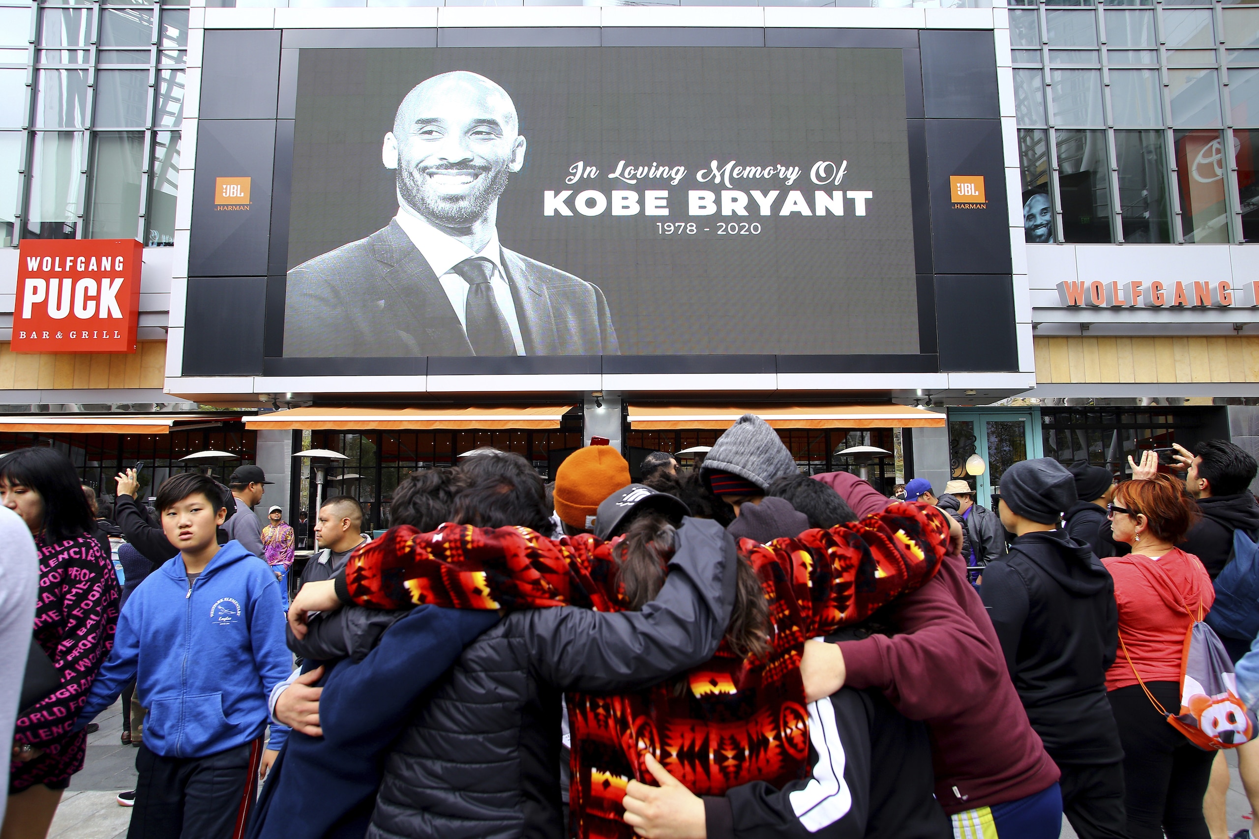 Fans of Kobe Bryant mourn in front of his image at the LALive area across from Staples Center, home of the Los Angeles Lakers, after word of the Lakers star's death in a helicopter crash, in downtown Los Angeles Sunday, Jan. 26, 2020. (AP Photo/Matt Hartman) Fans of Kobe Bryant mourn in front of his image at the LALive area across from Staples Center, home of the Los Angeles Lakers, after word of the Lakers star's death in a helicopter crash, in downtown Los Angeles Sunday, Jan. 26, 2020. (AP Photo/Matt Hartman)