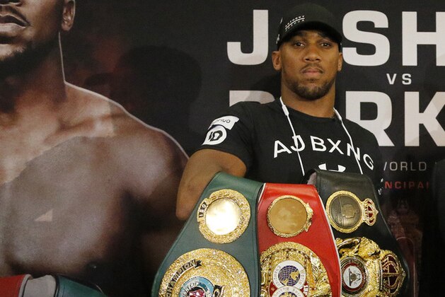 World Heavyweight boxers Anthony Joshua of Britain, left, and New Zealand's Joseph Parker hold their belts as they pose for photographers after a media conference in London, Tuesday, Jan. 16, 2018.  Their unification title bout with Joshua's IBF, WBA (Super) and IBO heavyweight titles and Parker's WBO heavyweight title on the line will take place at the Principality Stadium in Cardiff on March 31, 2018. (AP Photo/Frank Augstein)