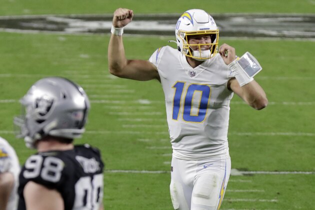 Los Angeles Chargers quarterback Justin Herbert (10) celebrates after running back Kalen Ballage scored a touchdown against the Las Vegas Raiders during the second half of an NFL football game, Thursday, Dec. 17, 2020, in Las Vegas. (AP Photo/Isaac Brekken)