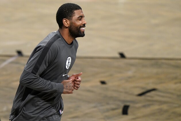 Brooklyn Nets guard Kyrie Irving smiles as he runs on the court before a preseason NBA basketball game against the Washington Wizards, Sunday, Dec. 13, 2020, in New York. (AP Photo/Kathy Willens)