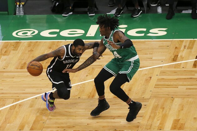 Brooklyn Nets guard Kyrie Irving (11) drives against Boston Celtics center Robert Williams III (44) during the first half of an NBA preseason basketball game, Friday, Dec. 18, 2020, in Boston. (AP Photo/Mary Schwalm)