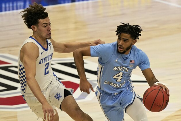 North Carolina's R.J. Davis (4) drives past Kentucky's Devin Askew (2) in the first half of an NCAA college basketball game, Saturday, Dec. 19, 2020, in Cleveland. (AP Photo/Tony Dejak)