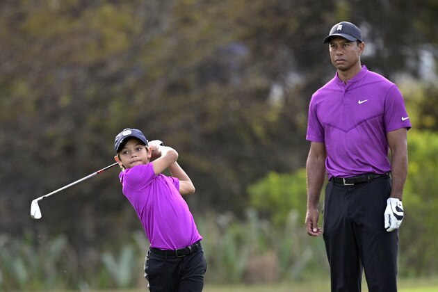 Tiger Woods, right, watches his son Charlie hit from the 15th fairway during the first round of the PNC Championship golf tournament, Saturday, Dec. 19, 2020, in Orlando, Fla. (AP Photo/Phelan M. Ebenhack)