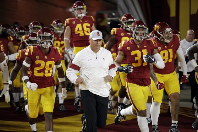 Southern California coach Clay Helton runs onto the field with this team for the start of an NCAA college football game against Arizona on Saturday, Oct. 19, 2019, in Los Angeles. (AP Photo/Marcio Jose Sanchez)