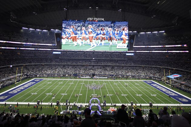 People walk the turf before the first half of the NFC wild-card NFL football game between the Dallas Cowboys and the Seattle Seahawks, in Arlington, Texas, Saturday, Jan. 5, 2019. (AP Photo/Roger Steinman)