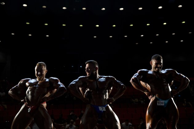 Contestants participate in the final round of the National Amateur Body Builders' Association competition in Tel Aviv, Israel on Thursday, Oct. 18, 2018. Dozens of glistening competitors took the stage for the annual body building and fitness competition. But behind the scenes, machismo makes way for cooperation. (AP Photo/Oded Balilty)