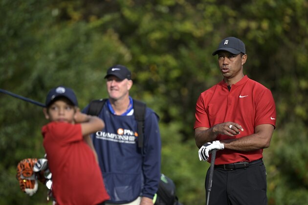 Tiger Woods, right, reacts as his son Charlie tees off on the first hole during the final round of the PNC Championship golf tournament, Sunday, Dec. 20, 2020, in Orlando, Fla. (AP Photo/Phelan M. Ebenhack)