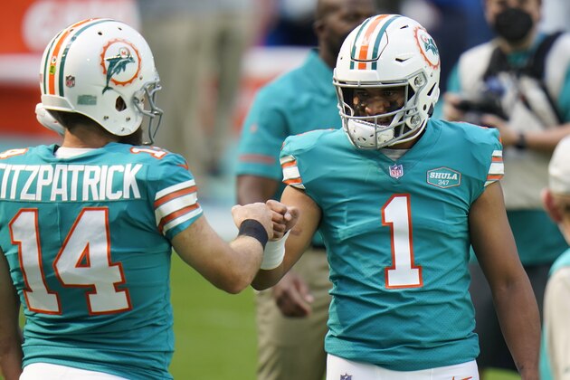 Miami Dolphins quarterback Tua Tagovailoa (1) greets quarterback Ryan Fitzpatrick (14) on the field before before an NFL football game against the New England Patriots, Sunday, Dec. 20, 2020, in Miami Gardens, Fla. (AP Photo/Chris O'Meara)
