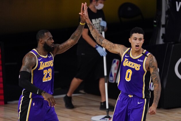 Los Angeles Lakers' LeBron James (23) celebrates with teammate Los Angeles Kyle Kuzma (0) during the first half of an NBA conference semifinal playoff basketball game against the Houston Rockets Friday, Sept. 4, 2020, in Lake Buena Vista, Fla. (AP Photo/Mark J. Terrill)