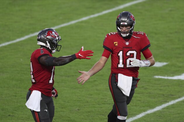 Tampa Bay Buccaneers quarterback Tom Brady (12) shakes hands with wide receiver Chris Godwin (14) during the first half of an NFL football game Sunday, Nov. 29, 2020, in Tampa, Fla. (AP Photo/Mark LoMoglio)