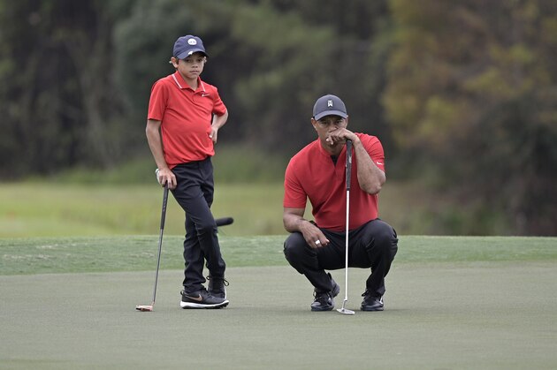 Tiger Woods, right, and his son Charlie line up a putt on the 12th green during the final round of the PNC Championship golf tournament, Sunday, Dec. 20, 2020, in Orlando, Fla. (AP Photo/Phelan M. Ebenhack)