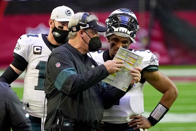 Philadelphia Eagles head coach Doug Pederson talks with starting quarterback Jalen Hurts as quarterback Carson Wentz (11) looks on during the first half of an NFL football game, Sunday, Dec. 20, 2020, in Glendale, Ariz. (AP Photo/Rick Scuteri)