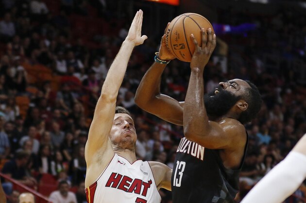 Houston Rockets guard James Harden (13) shoots next to Miami Heat guard Goran Dragic (7) during the first quarter of an NBA preseason basketball game Friday, Oct. 18, 2019, in Miami. (AP Photo/Joe Skipper)