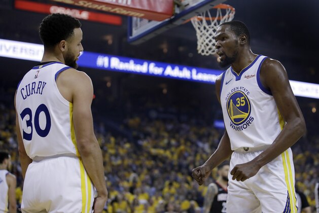 Golden State Warriors' Kevin Durant, right, speaks with Stephen Curry (30) after Curry was called for a foul during the first half of Game 5 of the team's second-round NBA basketball playoff series against the Houston Rockets on Wednesday, May 8, 2019, in Oakland, Calif. (AP Photo/Ben Margot)