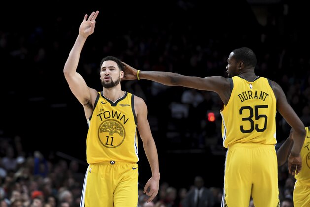 Golden State Warriors guard Klay Thompson, left, is patted on his head by forward Kevin Durant, right, after hitting a shot late in an NBA basketball game against the Portland Trail Blazers in Portland, Ore., Saturday, Dec. 29, 2018. The Warriors won 115-105. (AP Photo/Steve Dykes)