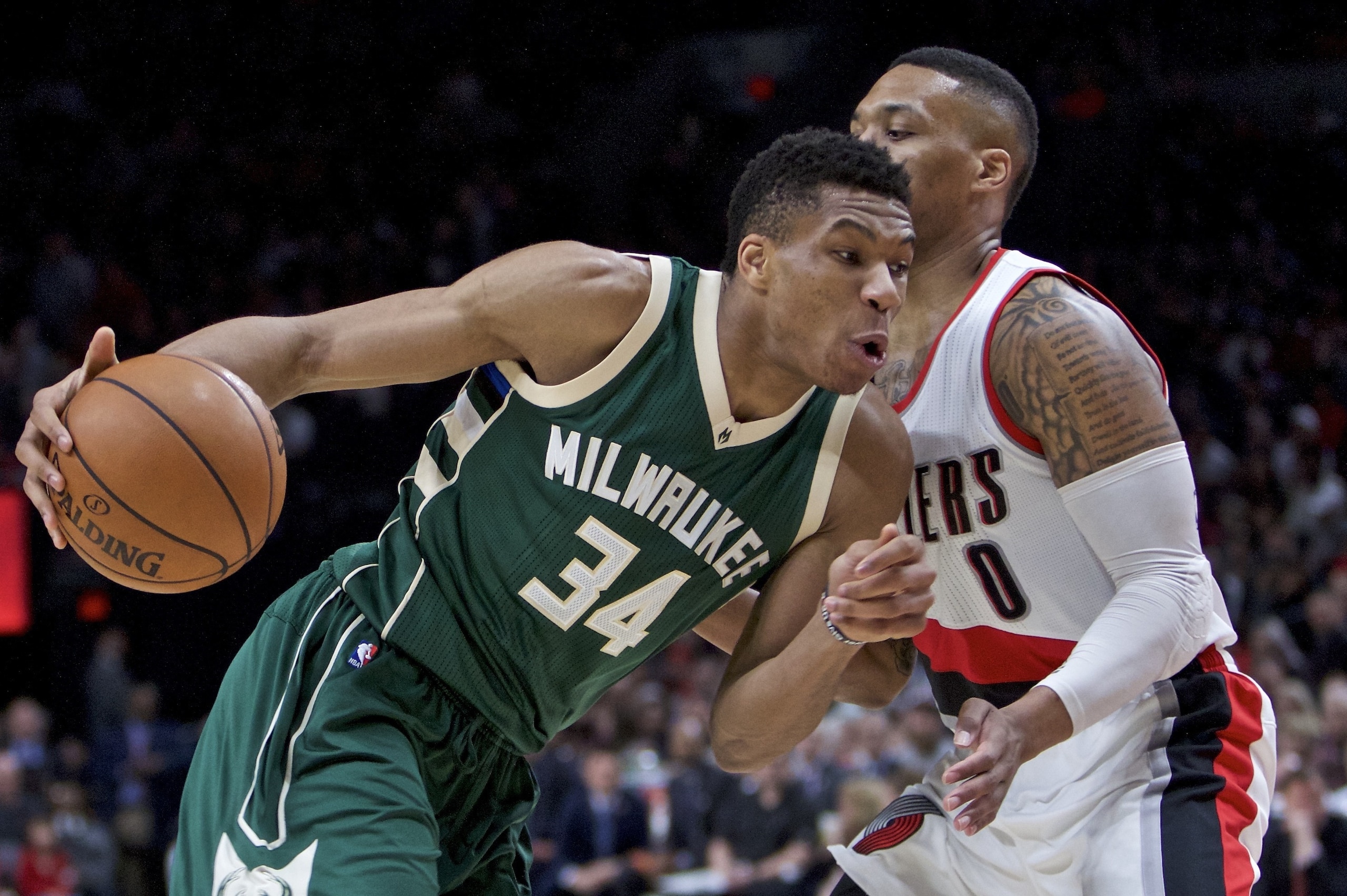 Milwaukee Bucks forward Giannis Antetokounmpo, left, dribbles past Portland Trail Blazers guard Damian Lillard during the first half of an NBA basketball game in Portland, Ore., Tuesday, March 21, 2017. (AP Photo/Craig Mitchelldyer)