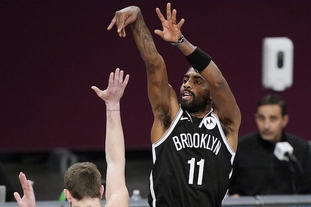 Brooklyn Nets guard Kyrie Irving (11) follows through on a shot during the first half of a preseason NBA basketball game against the Washington Wizards, Sunday, Dec. 13, 2020, in New York. (AP Photo/Kathy Willens)