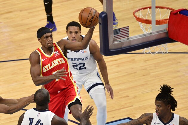 Atlanta Hawks guard Rajon Rondo (7) drives to the basket between Memphis Grizzlies center Gorgui Dieng (14) and guards De'Anthony Melton (0), Ja Morant (12) and Desmond Bane (22) in the second half of an NBA preseason basketball game Thursday, Dec. 17, 2020, in Memphis, Tenn. (AP Photo/Brandon Dill)
