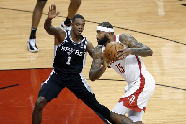 Houston Rockets center DeMarcus Cousins (15) looks to pass under pressure from San Antonio Spurs guard Lonnie Walker IV (1) during the first half of an NBA basketball game Tuesday, Dec. 15, 2020, in Houston. (AP Photo/Michael Wyke)