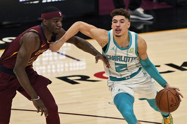 Charlotte Hornets' LaMelo Ball (2) drives past Cleveland Cavaliers' Damyean Dotson during the second half of an NBA basketball game, Wednesday, Dec. 23, 2020, in Cleveland. (AP Photo/Tony Dejak)