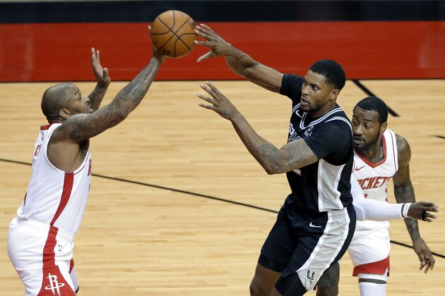 Houston Rockets forward P.J. Tucker, left, deflects a pass by San Antonio Spurs forward Rudy Gay, middle, in front of guard John Wall, right, during the second half of an NBA basketball game Tuesday, Dec. 15, 2020, in Houston. (AP Photo/Michael Wyke)