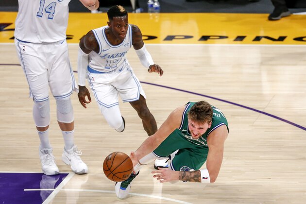 Dallas Mavericks' Luka Doncic falls to the court after being fouled by Los Angeles Lakers' Dennis Schroeder (17) during the second half of an NBA basketball game Friday, Dec. 25, 2020, in Los Angeles. The Lakers won 138-115. (AP Photo/Ringo H.W. Chiu)