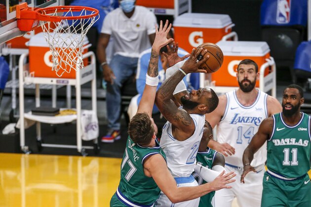 Los Angeles Lakers' LeBron James (23) goes to the basket while defended by Dallas Mavericks' Luka Doncic (77) during the first half of an NBA basketball game Friday, Dec. 25, 2020, in Los Angeles. (AP Photo/Ringo H.W. Chiu)