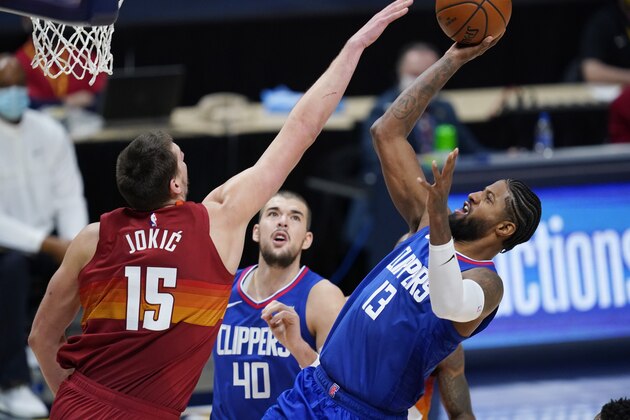 Los Angeles Clippers guard Paul George shoots as Denver Nuggets center Nikola Jokic defends during the second half of an NBA basketball game Friday, Dec. 25, 2020, in Denver. (AP Photo/David Zalubowski)