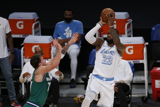 Los Angeles Lakers' LeBron James (23) shoots against Dallas Mavericks' Luka Doncic (77) during the first half of an NBA basketball game Friday, Dec. 25, 2020, in Los Angeles. (AP Photo/Ringo H.W. Chiu)