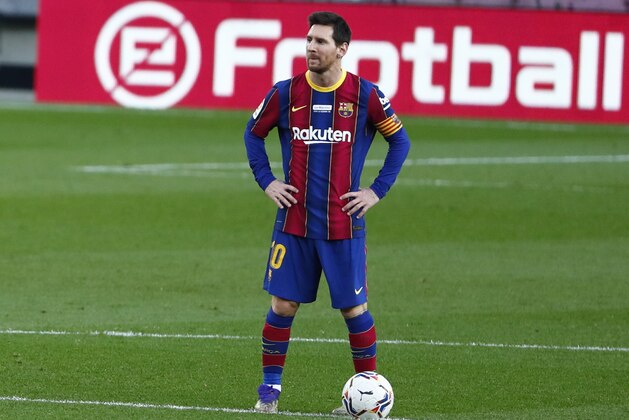 Barcelona's Lionel Messi waits in the centre circle to restart the match after Valencia scored the opening goal of the game during the Spanish La Liga soccer match between Barcelona and Valencia at the Camp Nou stadium in Barcelona, Spain, Saturday, Dec. 19, 2020. (AP Photo/Joan Monfort)