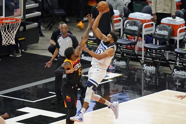 Minnesota Timberwolves center Karl-Anthony Towns (32) shoots as Utah Jazz center Derrick Favors (15) defends during the second half of an NBA basketball game Saturday, Dec. 26, 2020, in Salt Lake City. (AP Photo/Rick Bowmer)